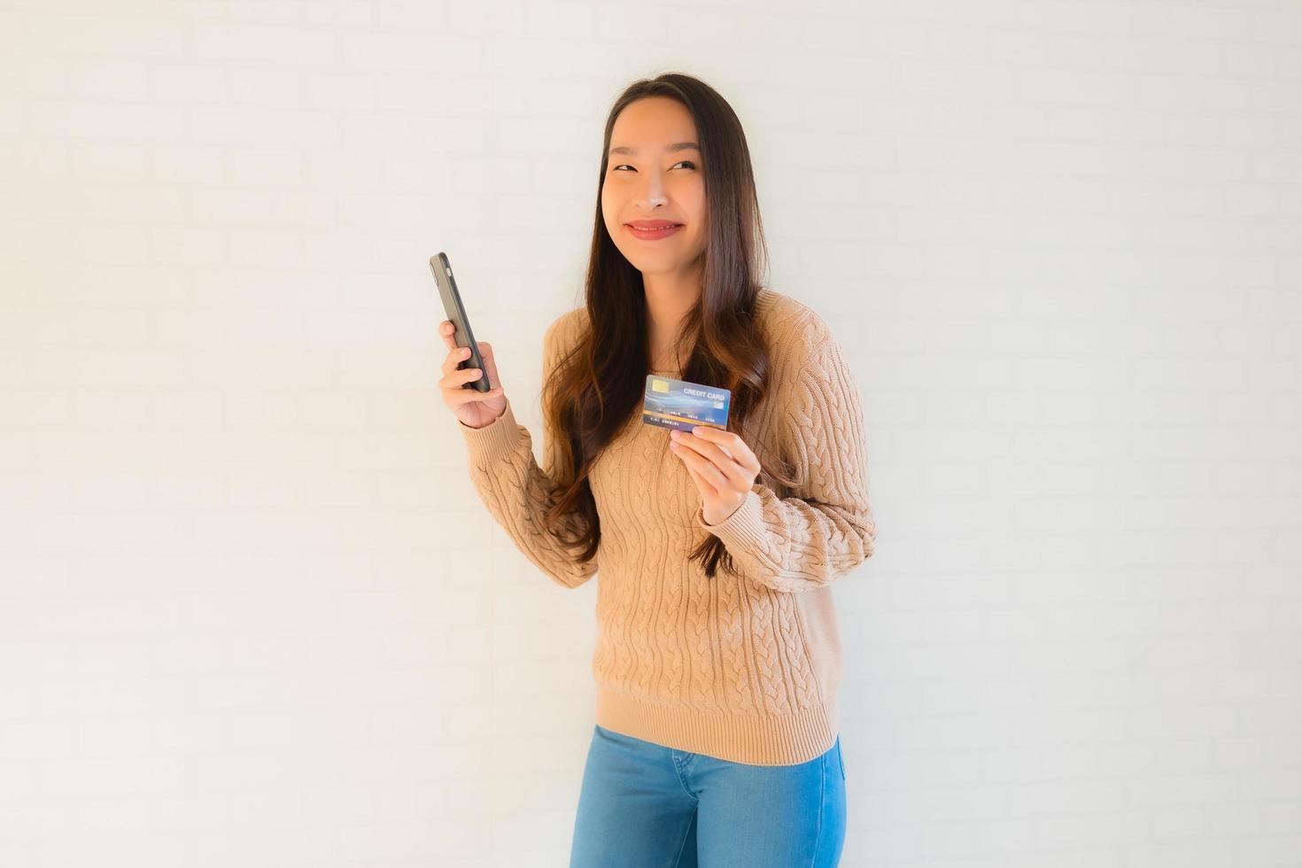 Portrait beautiful young asian use mobile smart phone with credit card photo