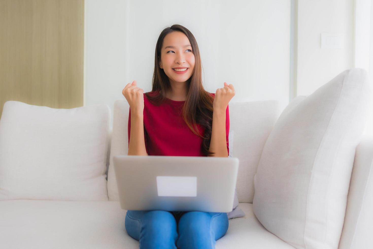 retrato, hermoso, joven, mujeres asiáticas, utilizar, computadora portátil, en, sofá, sillón foto