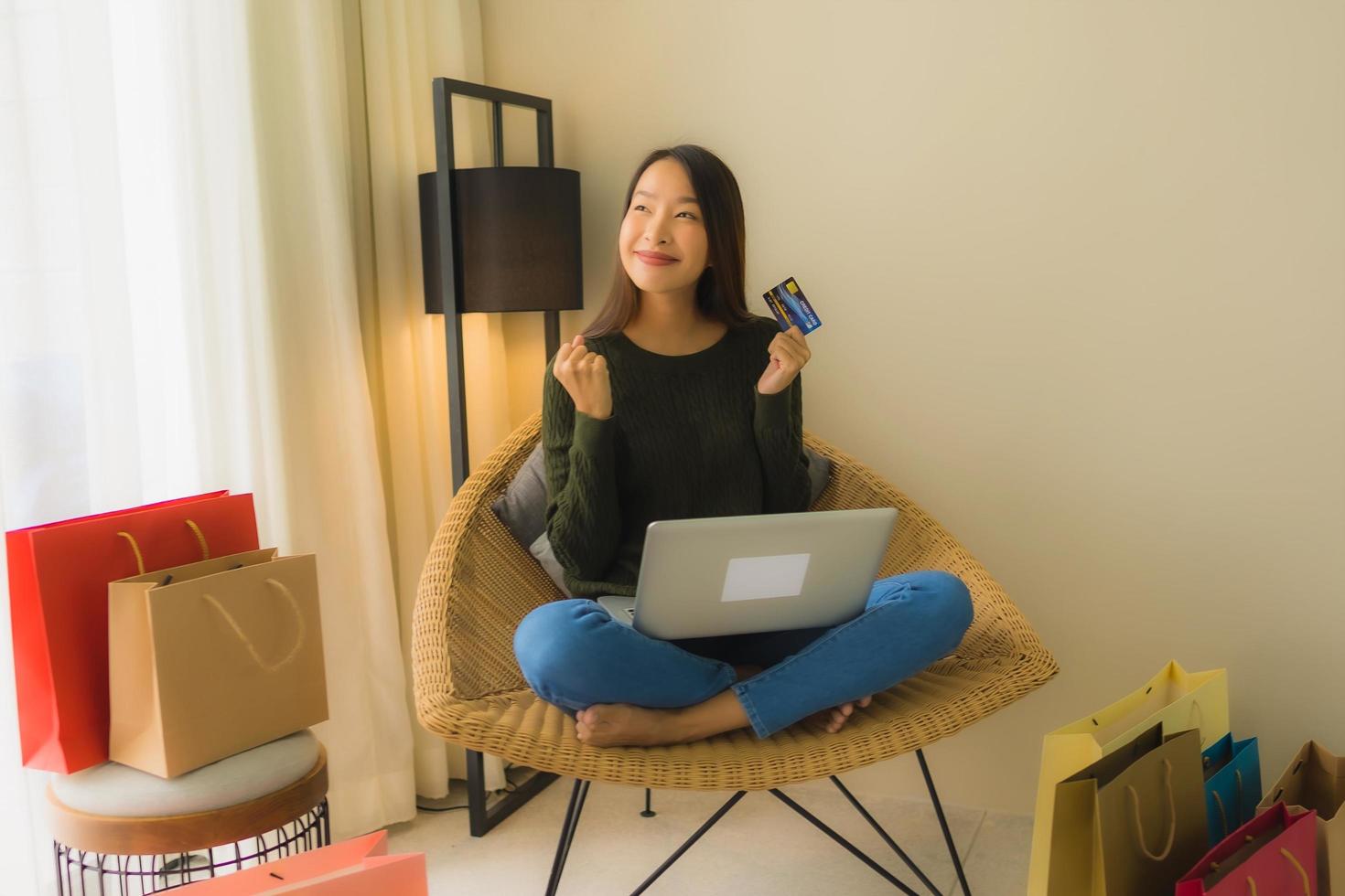 Retrato de hermosas mujeres asiáticas jóvenes usando computadora portátil o teléfono inteligente y móvil con tarjeta de crédito para compras en línea foto