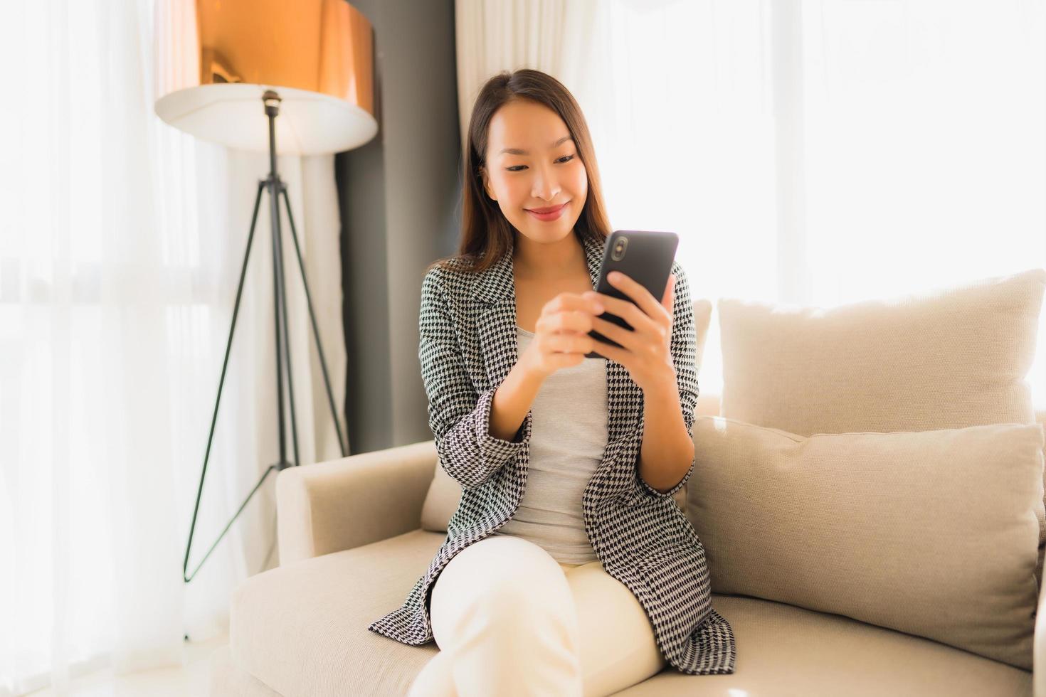 Portrait beautiful young asian women using talking mobile phone and sitting on sofa chair photo