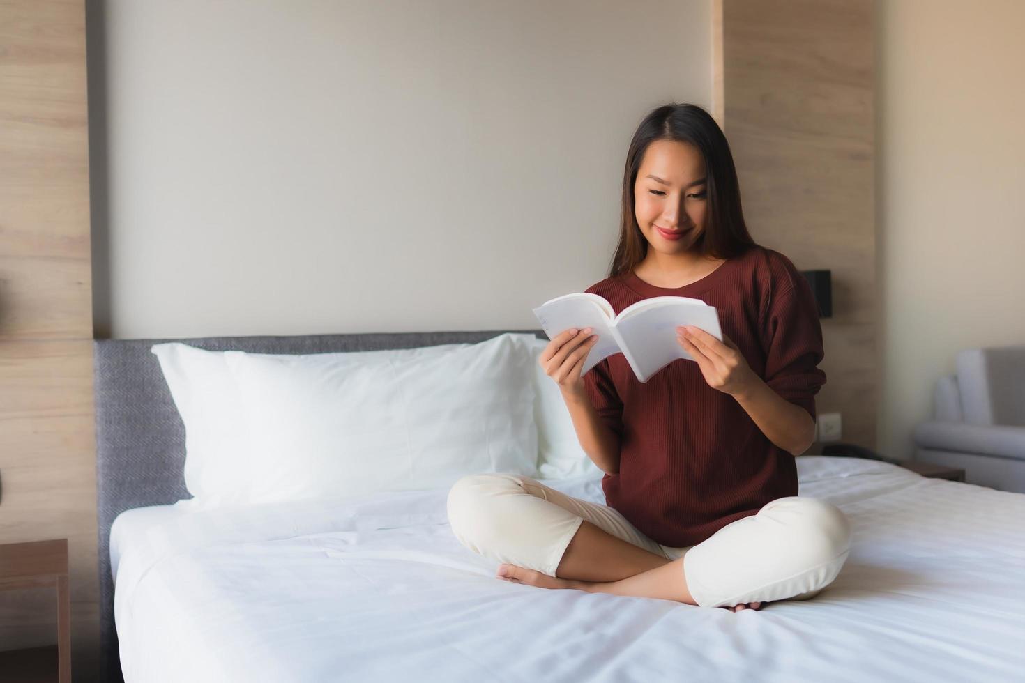 retrato, hermoso, joven, mujeres asiáticas, libro de lectura, en cama foto