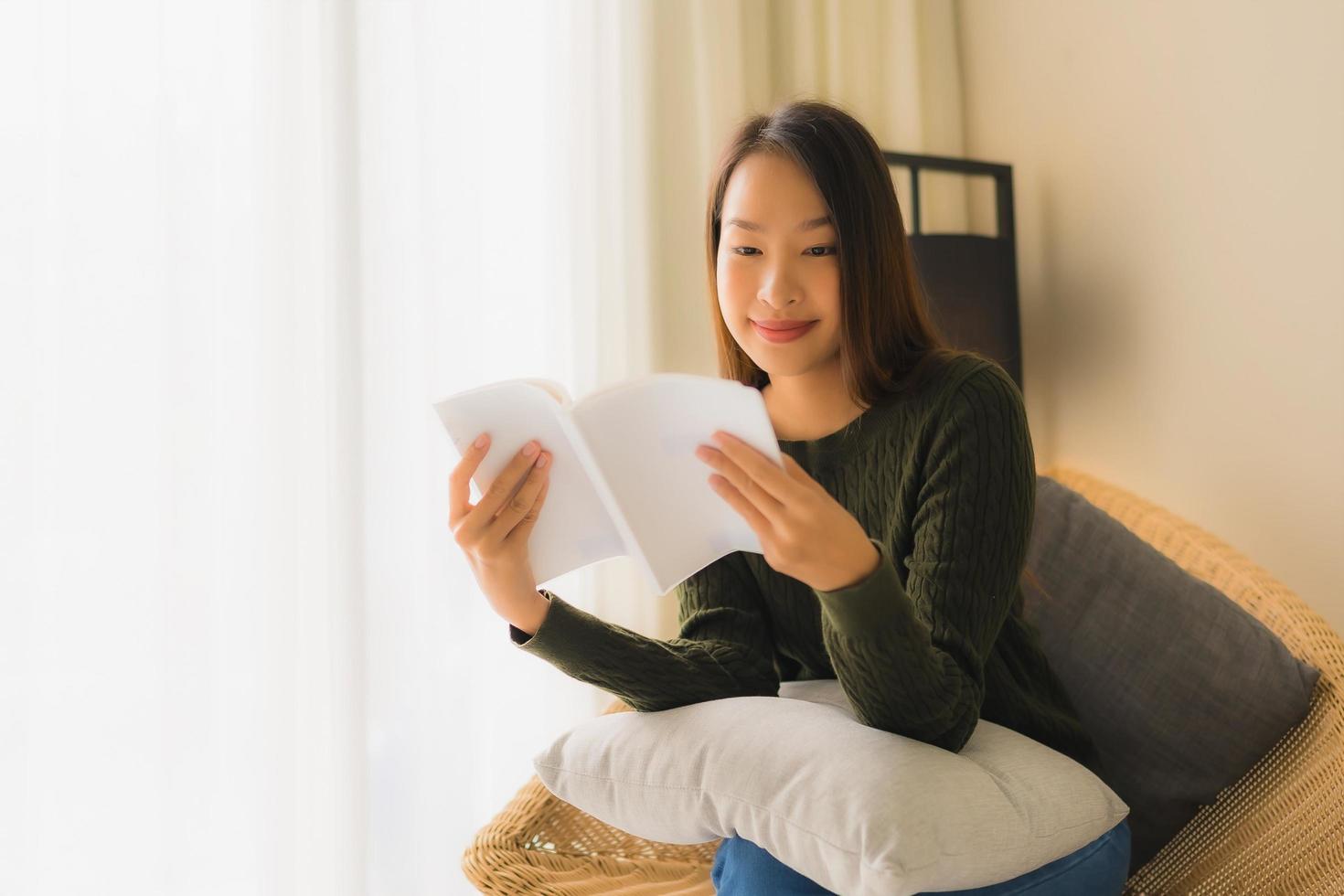 retrato, hermoso, joven, mujeres asiáticas, libro de lectura, y, sentar sofá, sillón foto