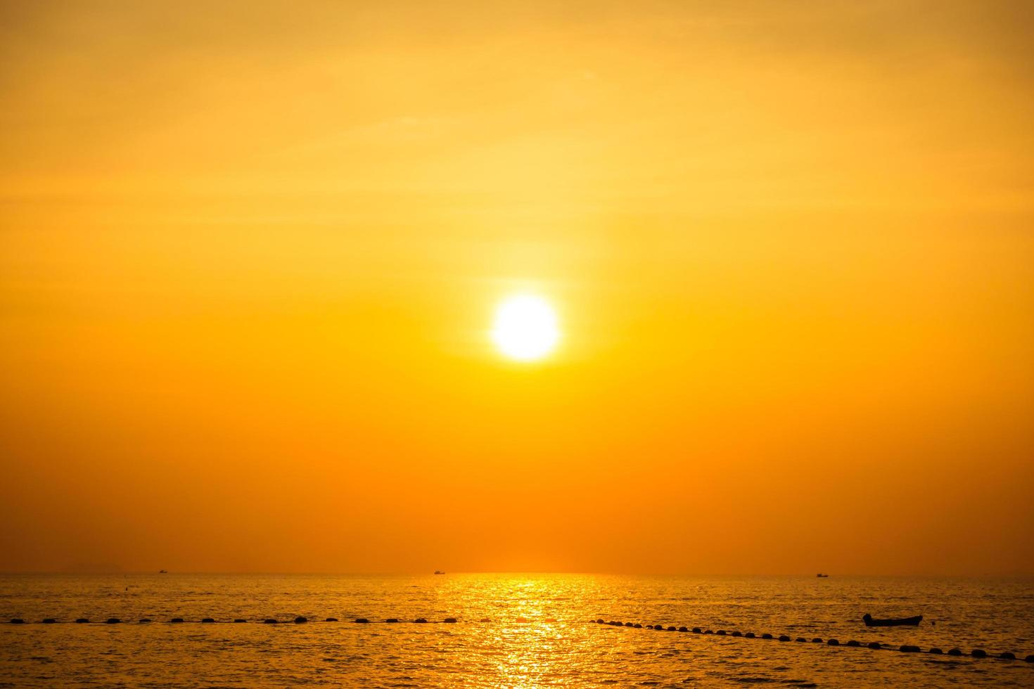 hermosa puesta de sol en la playa y el mar foto