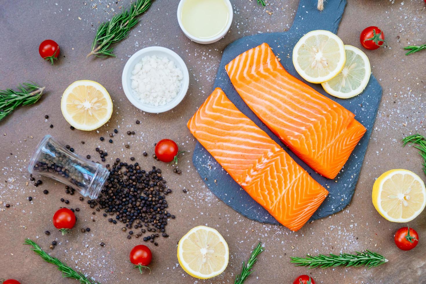 Raw and fresh salmon meat fillet on black stone slate photo