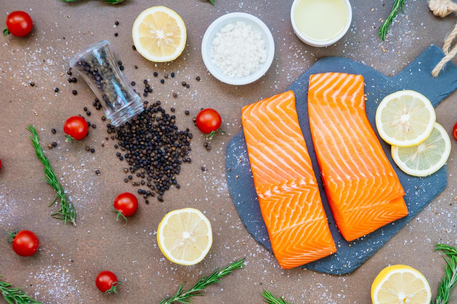 Filete de carne de salmón crudo y fresco sobre pizarra de piedra negra foto