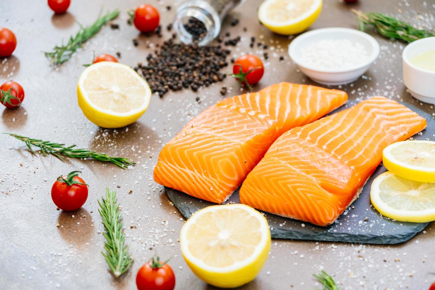 Raw and fresh salmon meat fillet on black stone slate photo