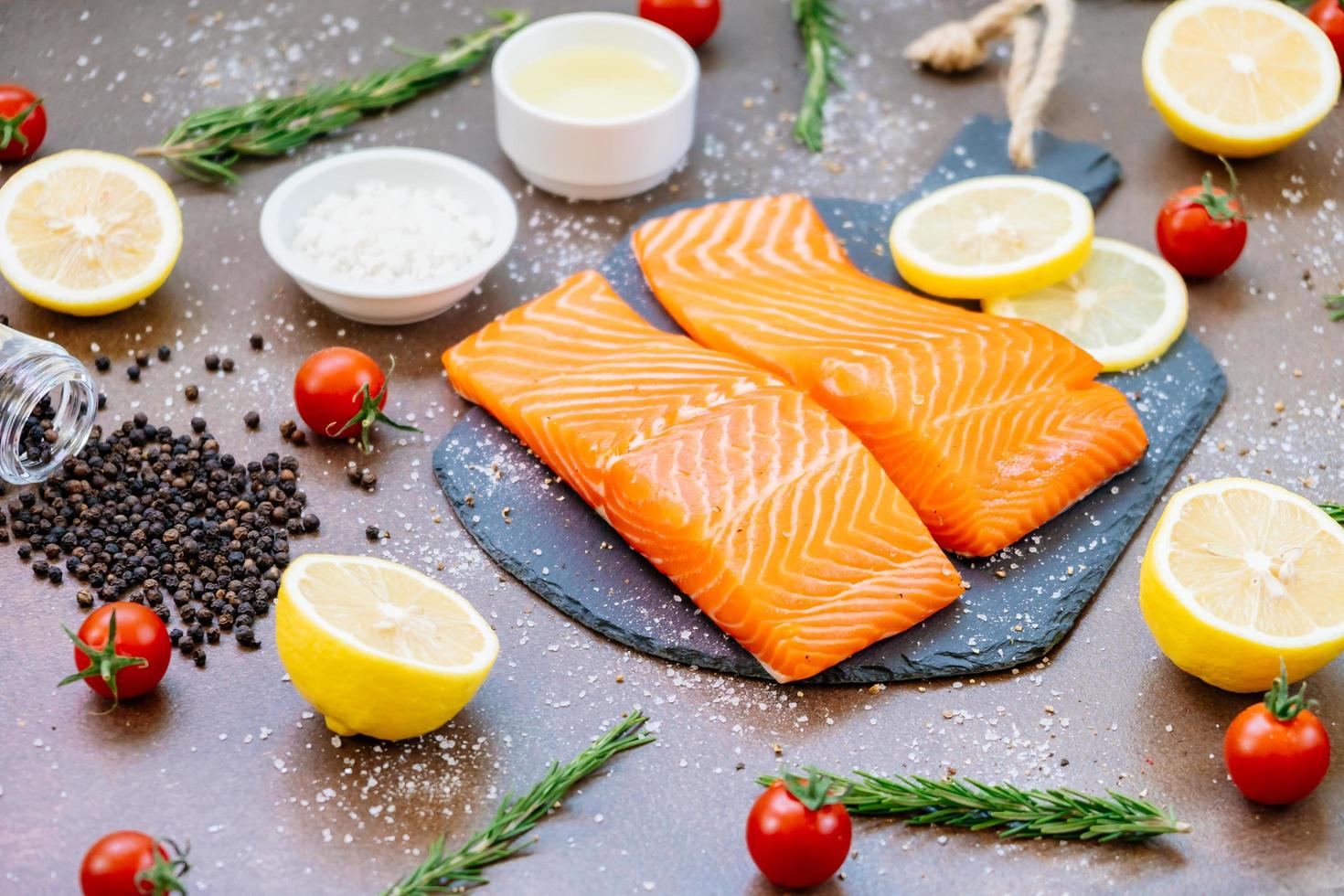 Raw and fresh salmon meat fillet on black stone slate photo