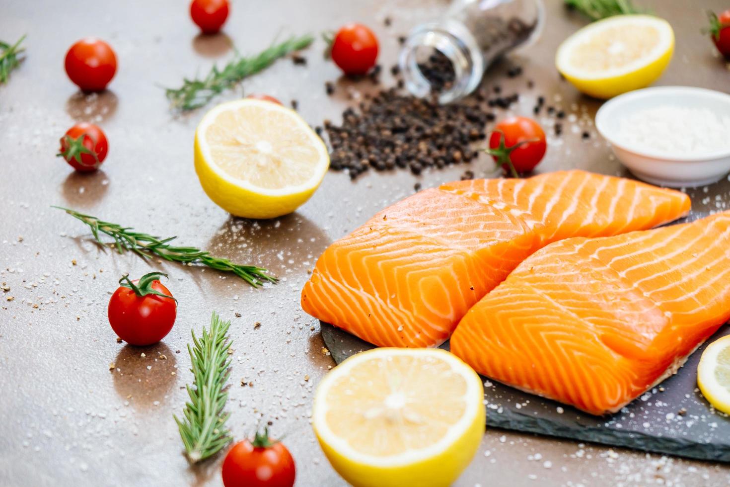 Raw and fresh salmon meat fillet on black stone slate photo