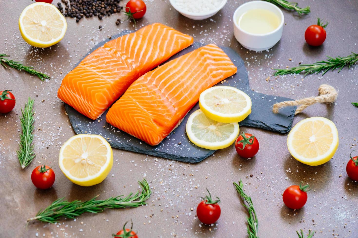 Raw and fresh salmon meat fillet on black stone slate photo