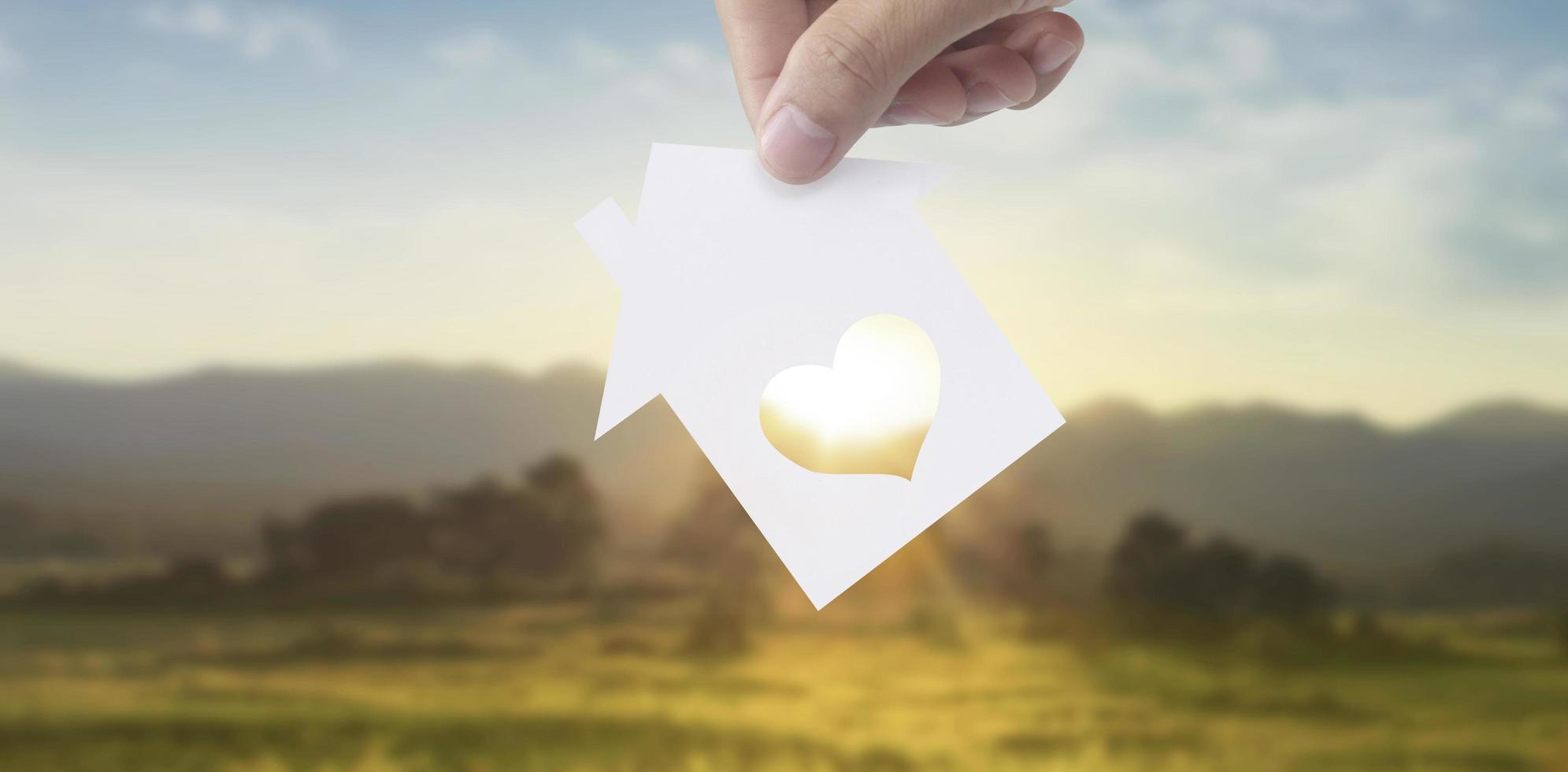 Hands holding paper house, family home  protecting insurance concept photo