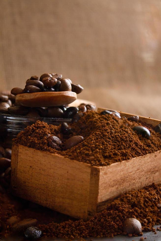 Still life with coffee beans and old coffee mill on the rustic background photo