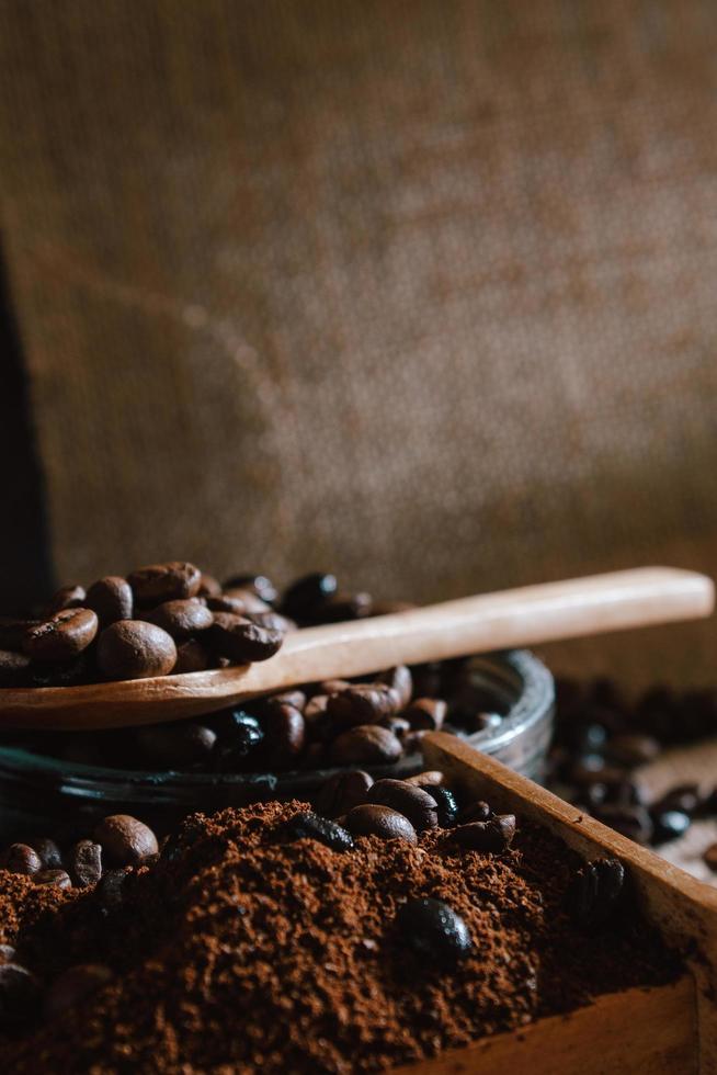 Bodegón con granos de café y antiguo molino de café en el fondo rústico foto