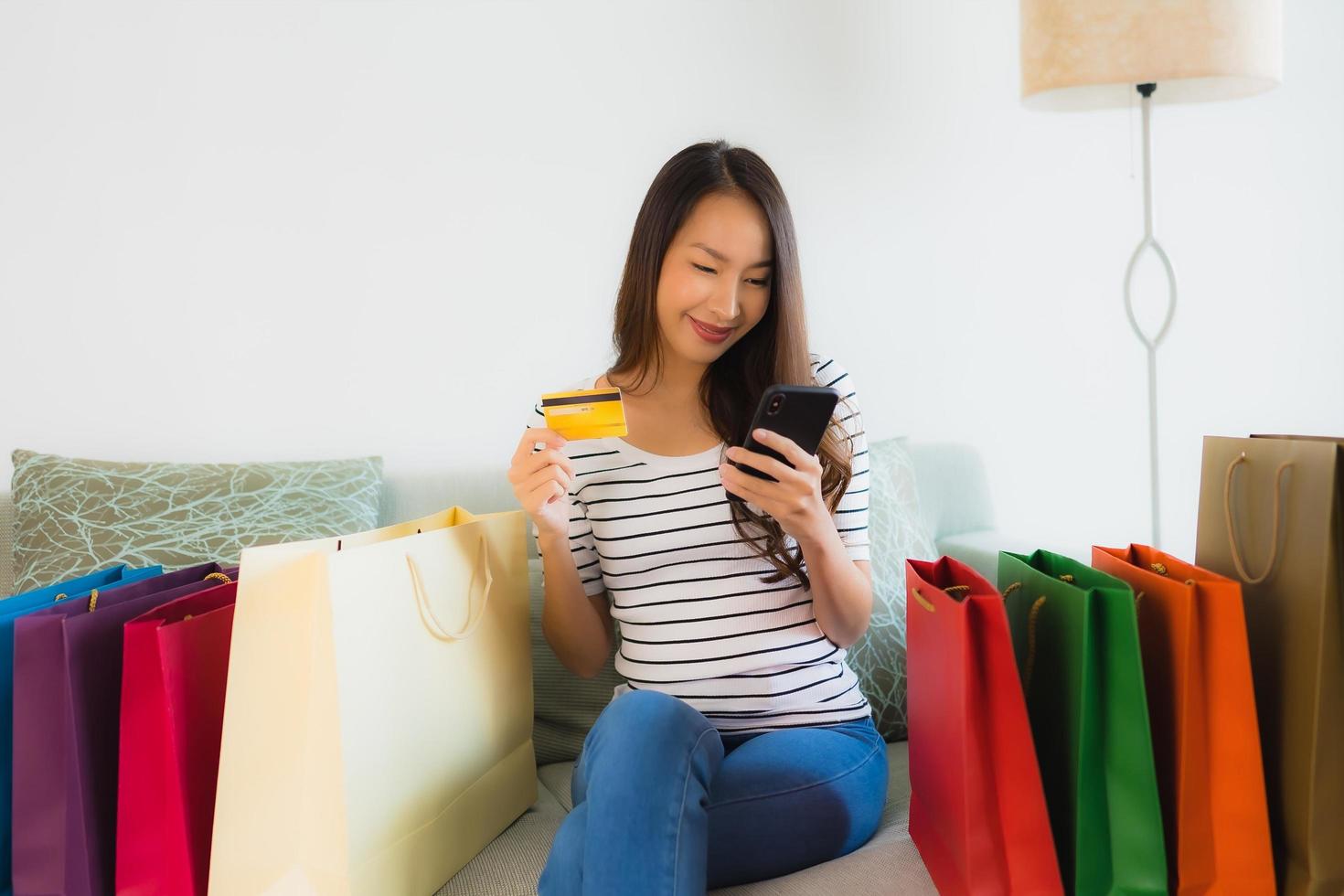 Retrato de hermosas mujeres asiáticas jóvenes con tarjeta de crédito, teléfono móvil o computadora para ir de compras foto