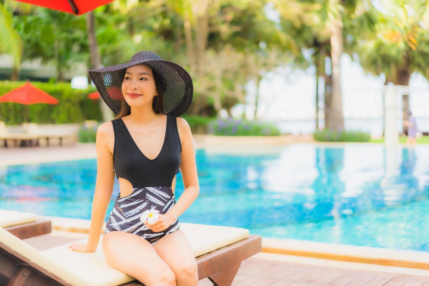 retrato, hermoso, joven, mujeres asiáticas, feliz, sonrisa, relajarse, alrededor, piscina foto