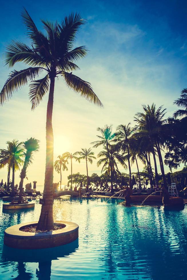 Silhouette coconut palm tree around swimming pool photo