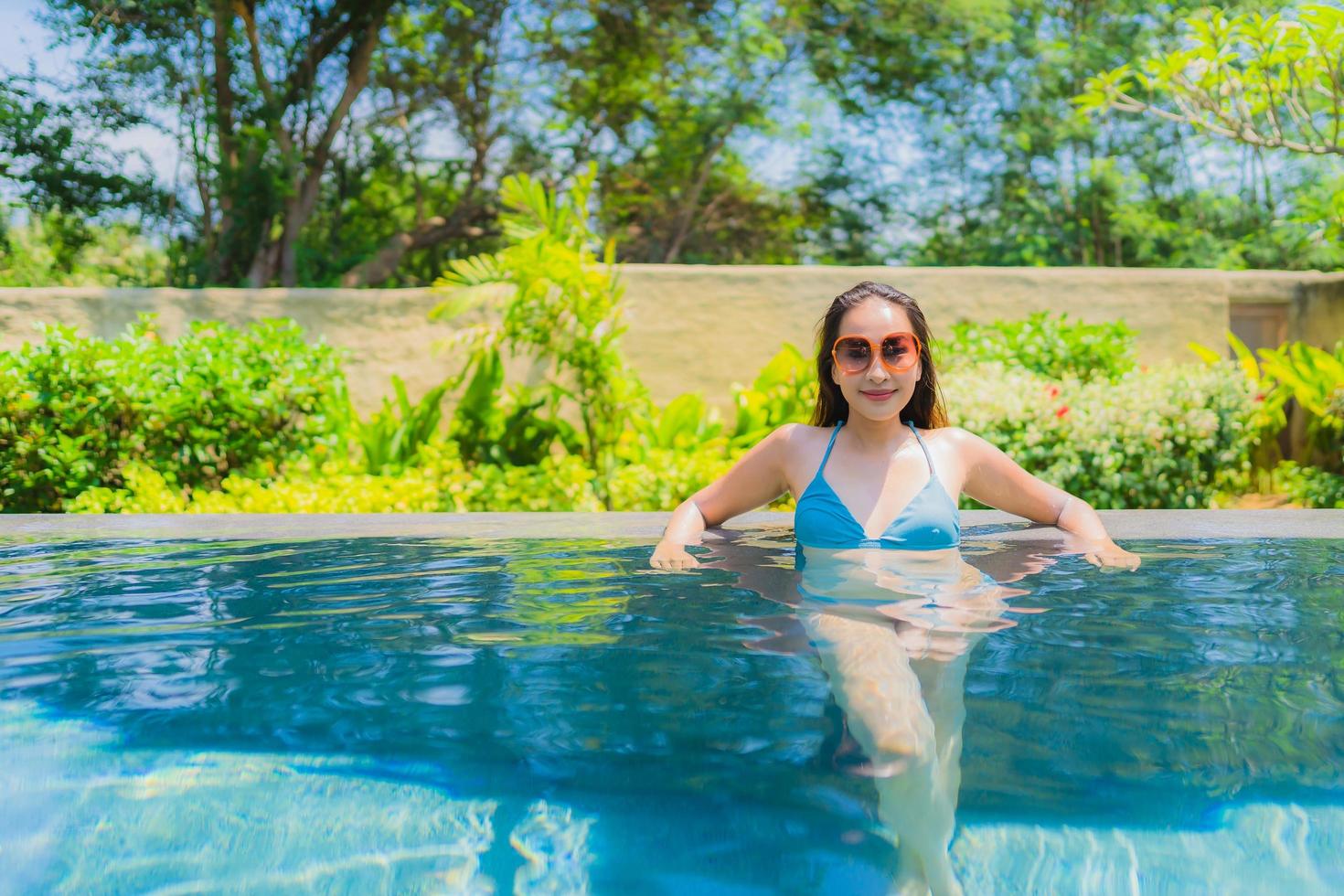 Portrait beautiful young asian woman smile happy relax and leisure in the swimming pool photo