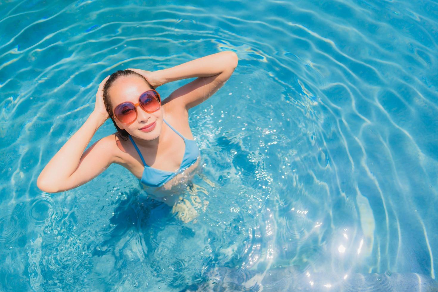 Portrait beautiful young asian woman smile happy relax and leisure in the swimming pool photo