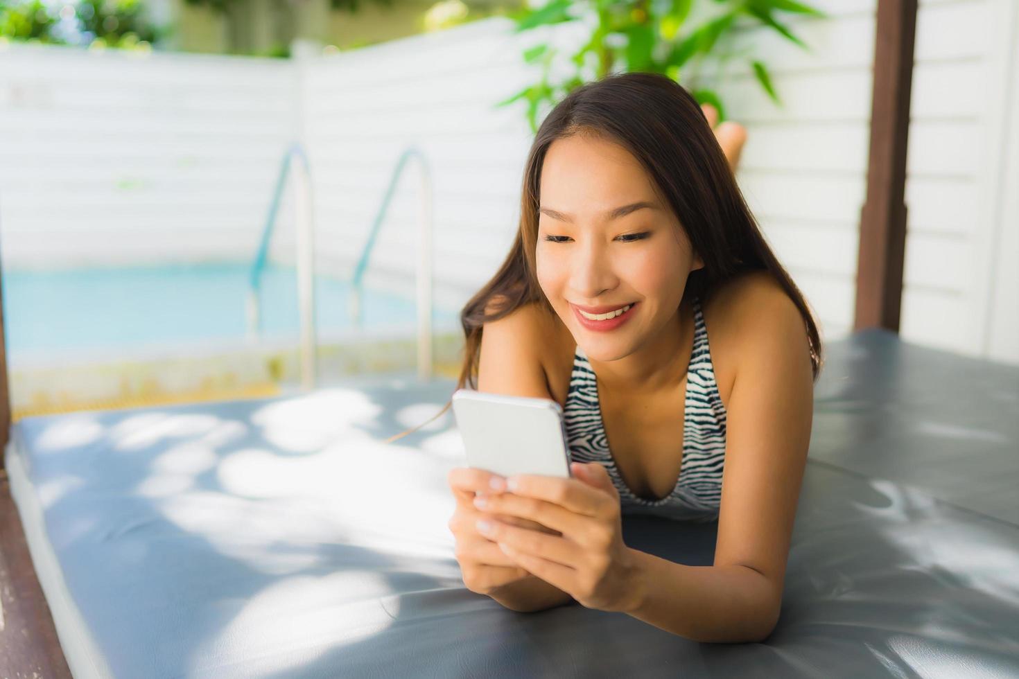 Portrait beautiful young asian woman happy smile talk mobile phone around swimming pool photo