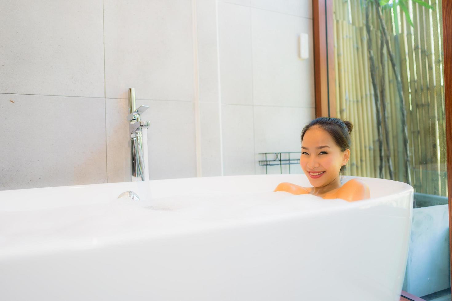 Portrait young beautiful asian woman take a bath in bathtub photo