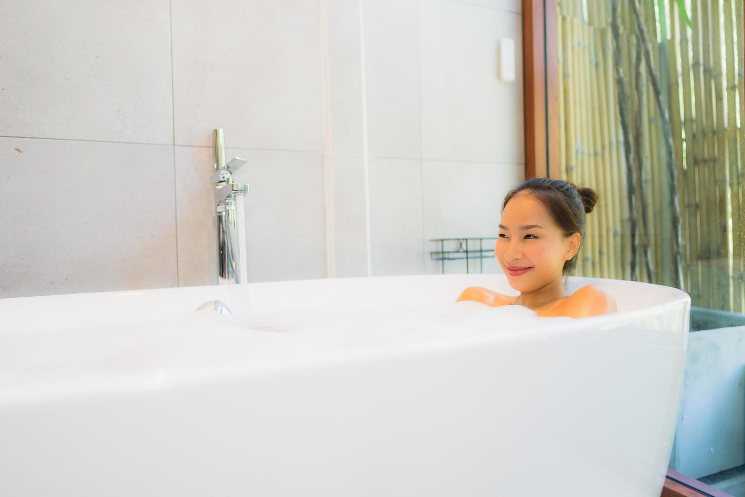 Portrait young beautiful asian woman take a bath in bathtub photo