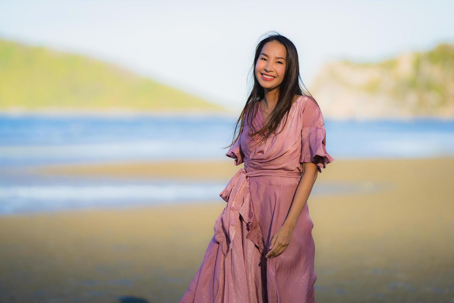 retrato, joven, hermoso, mujer asiática, caminar, sonrisa, y, feliz, en, el, playa, mar y océano foto