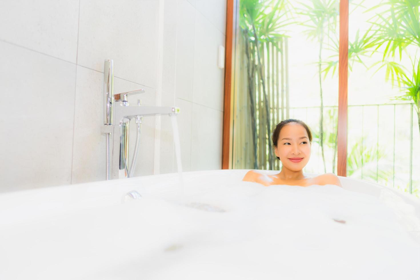 Portrait young beautiful asian woman take a bath in bathtub photo