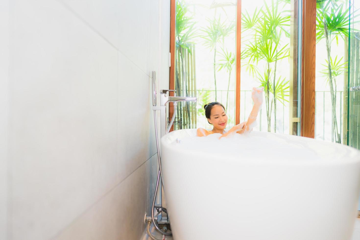 Portrait young beautiful asian woman take a bath in bathtub photo