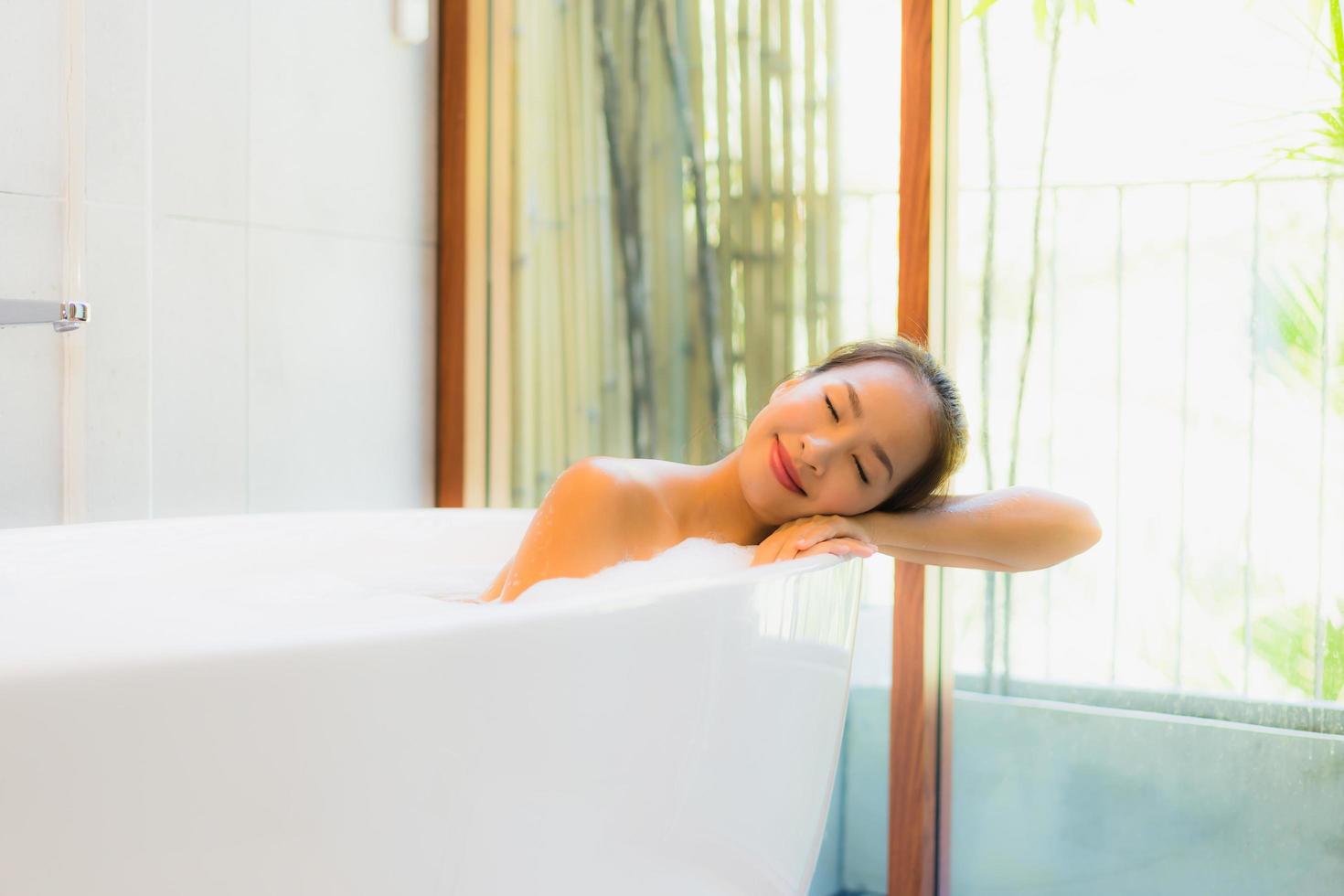 Portrait young beautiful asian woman take a bath in bathtub photo