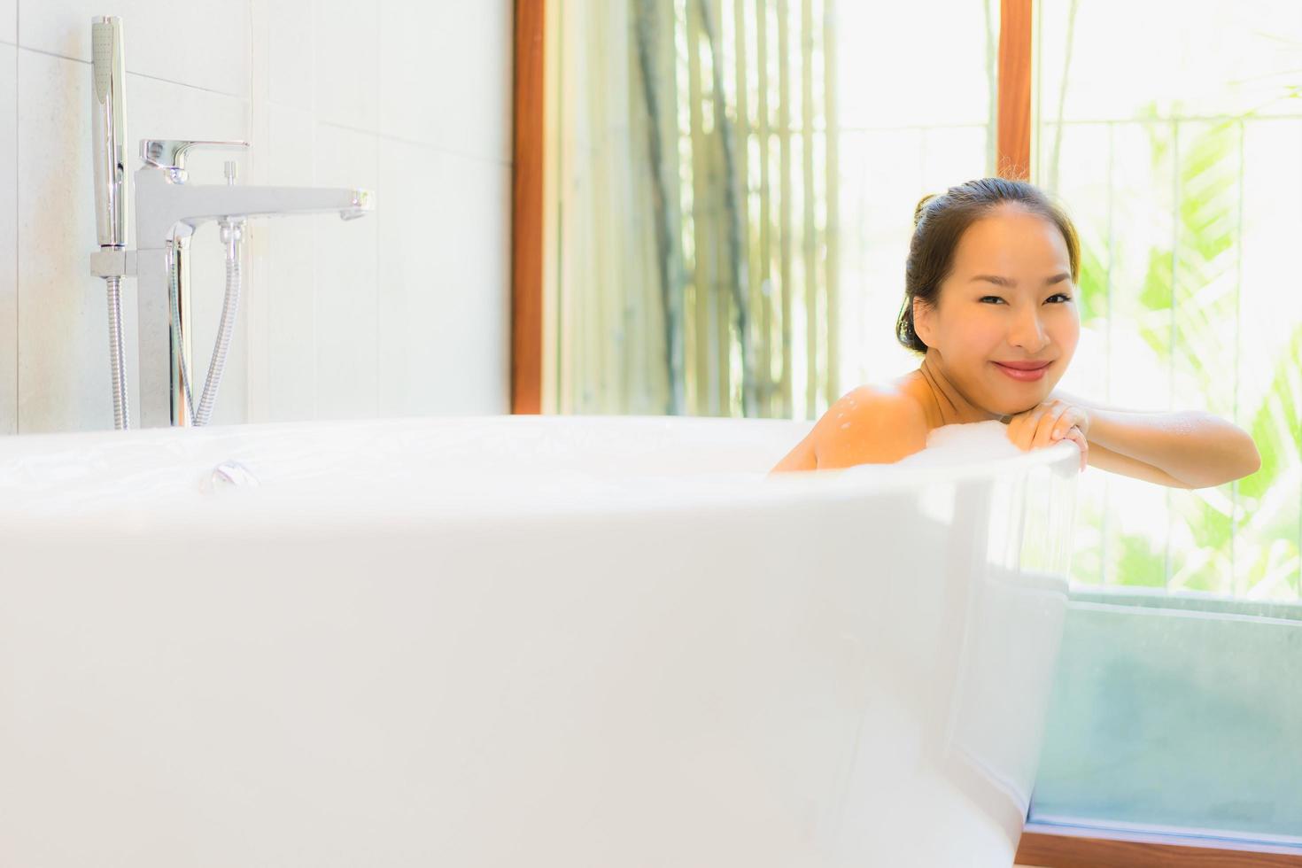 Portrait young beautiful asian woman take a bath in bathtub photo