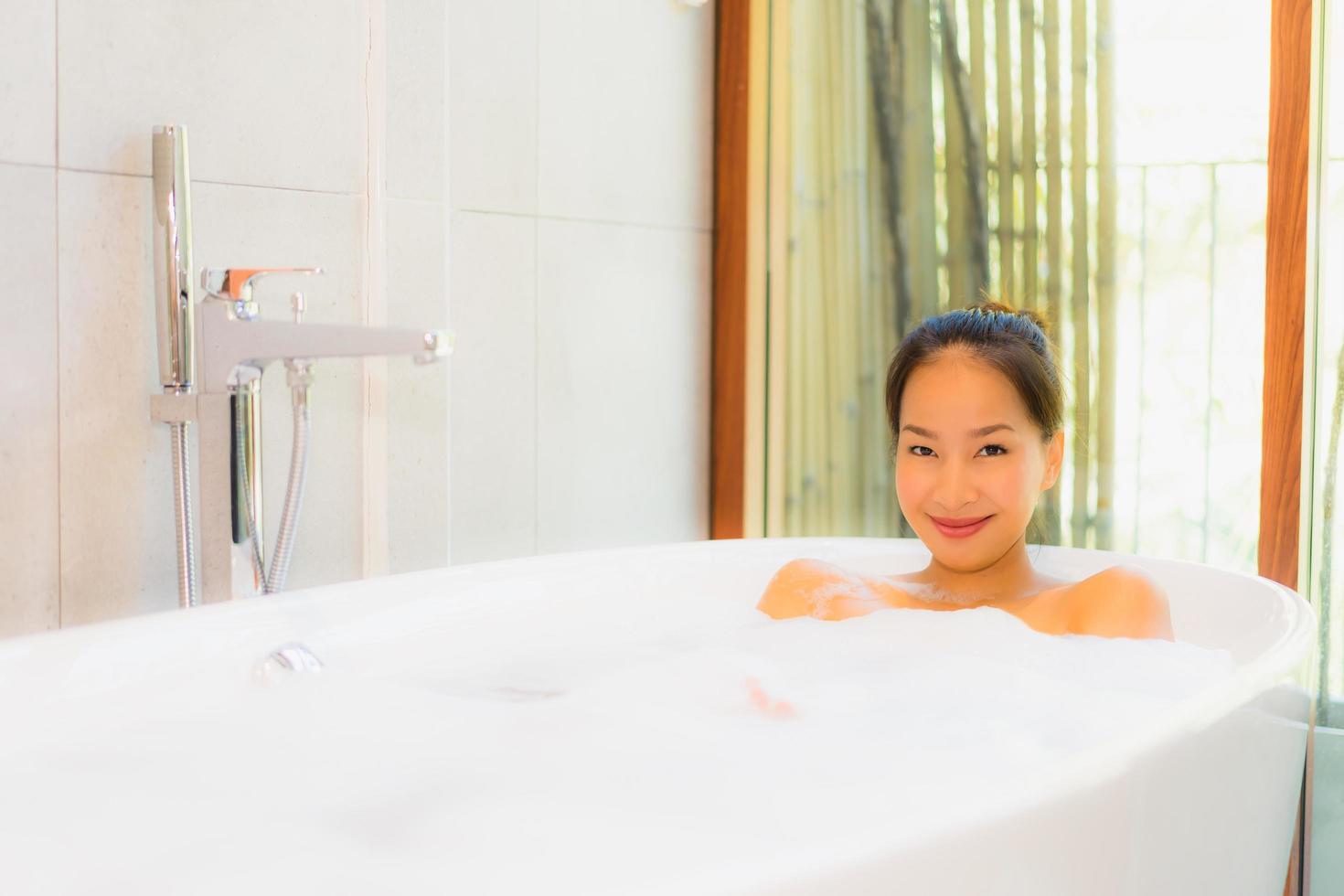 Portrait young beautiful asian woman take a bath in bathtub photo