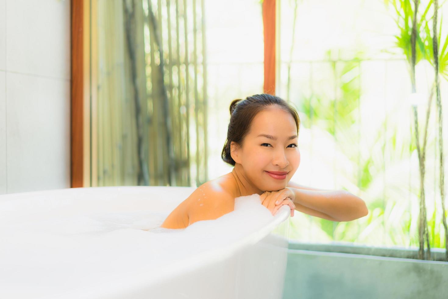 Portrait young beautiful asian woman take a bath in bathtub photo