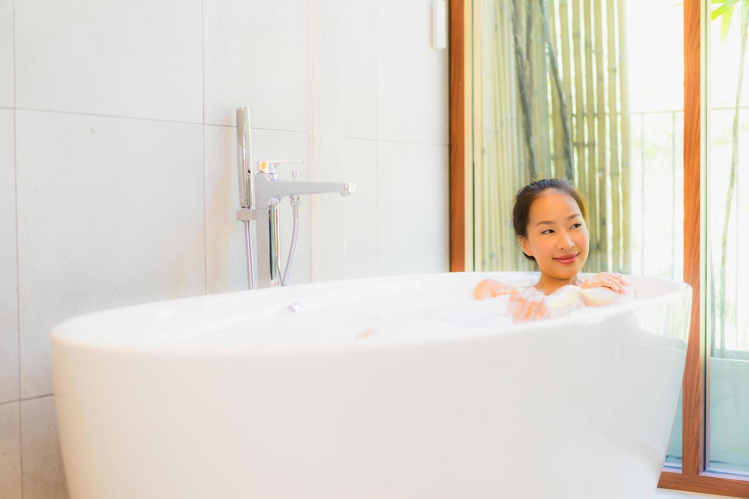 Portrait young beautiful asian woman take a bath in bathtub photo