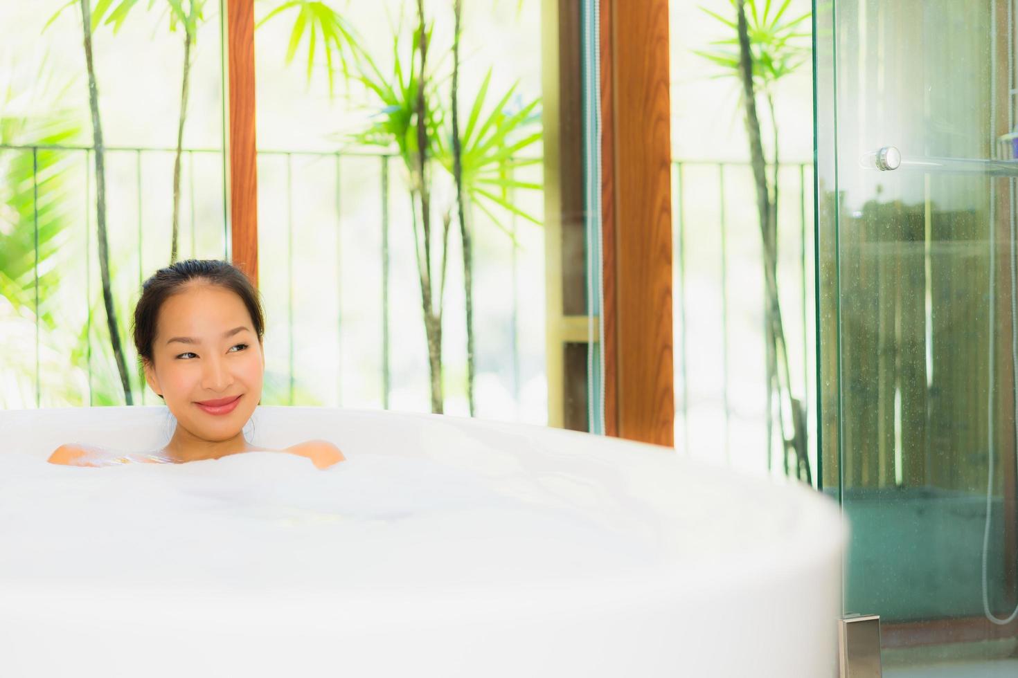 Portrait young beautiful asian woman take a bath in bathtub photo