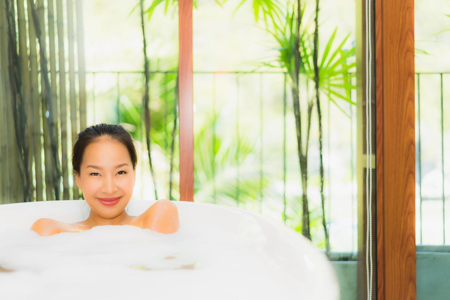 Portrait young beautiful asian woman take a bath in bathtub photo