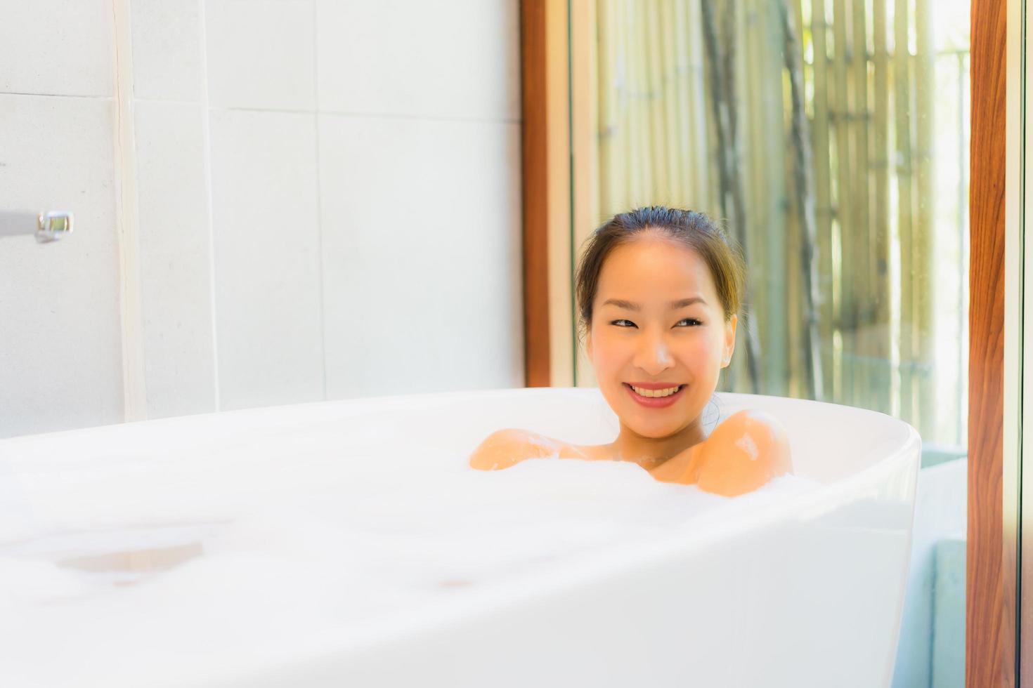 Portrait young beautiful asian woman take a bath in bathtub photo