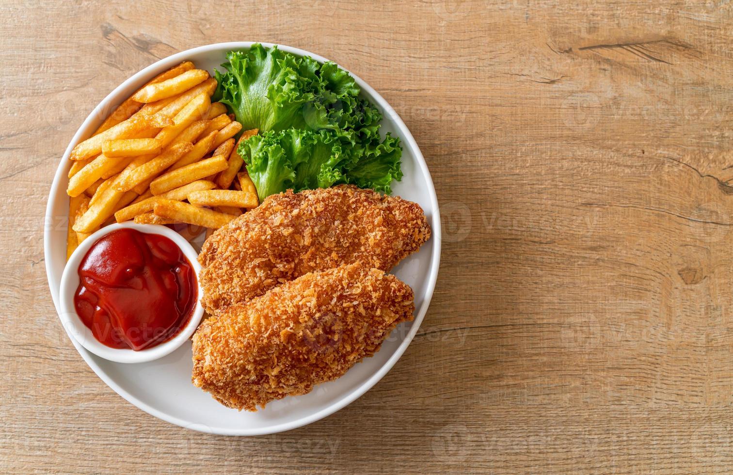 Filete de pechuga de pollo frito con papas fritas y salsa de tomate foto