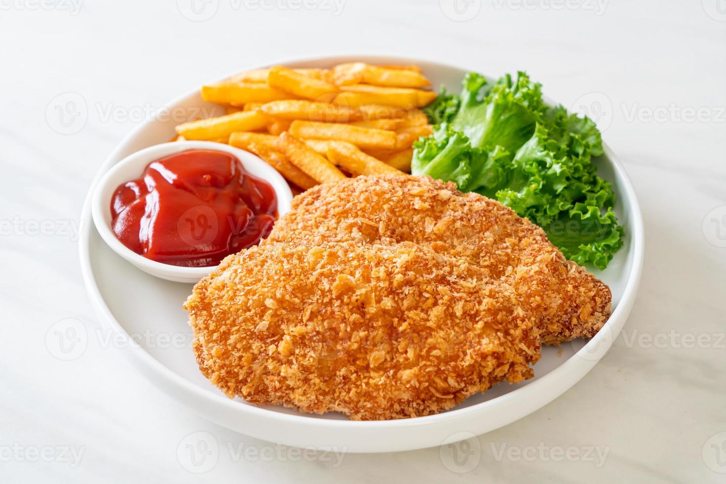 Filete de pechuga de pollo frito con papas fritas y salsa de tomate foto