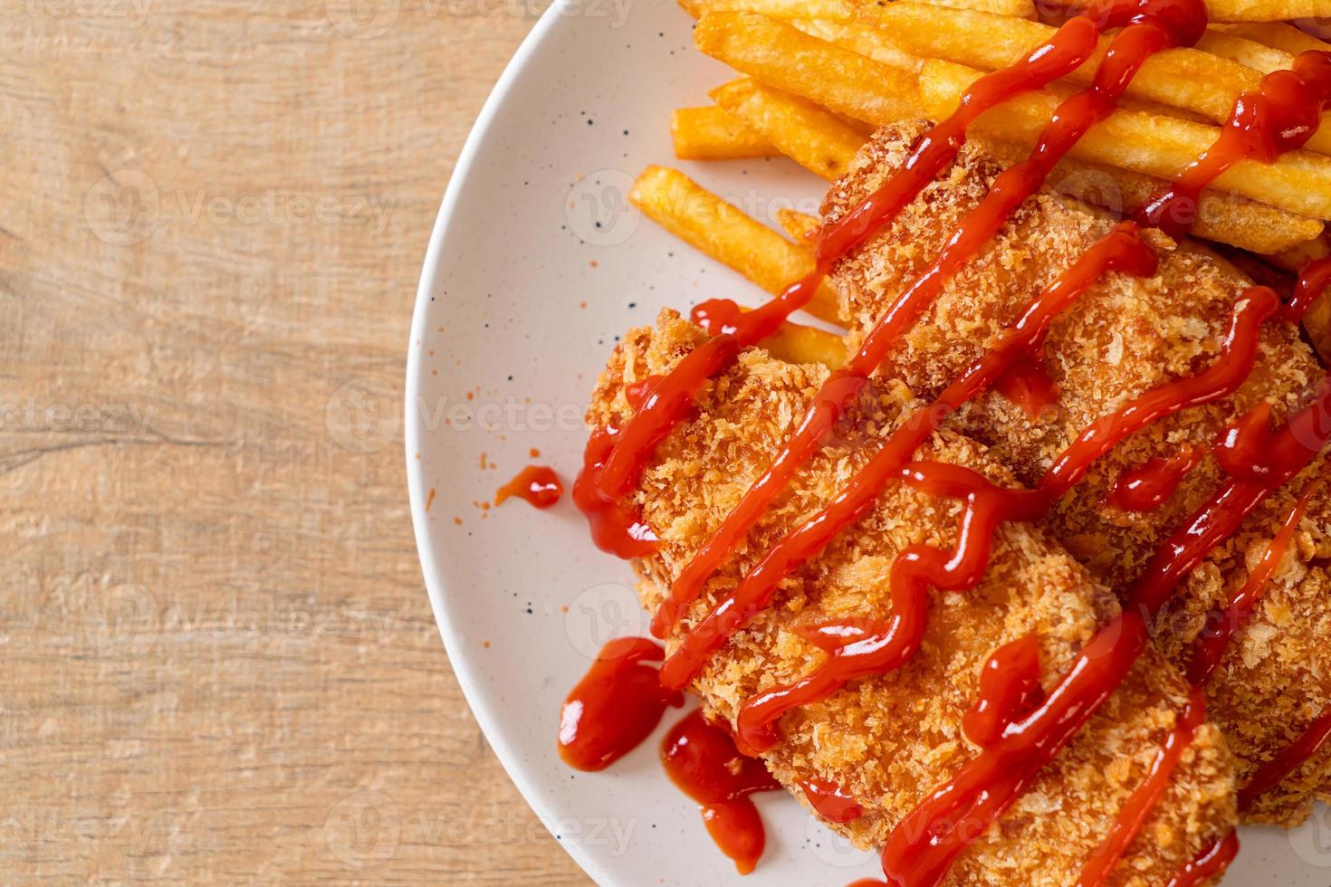 Filete de pechuga de pollo frito con papas fritas y salsa de tomate foto