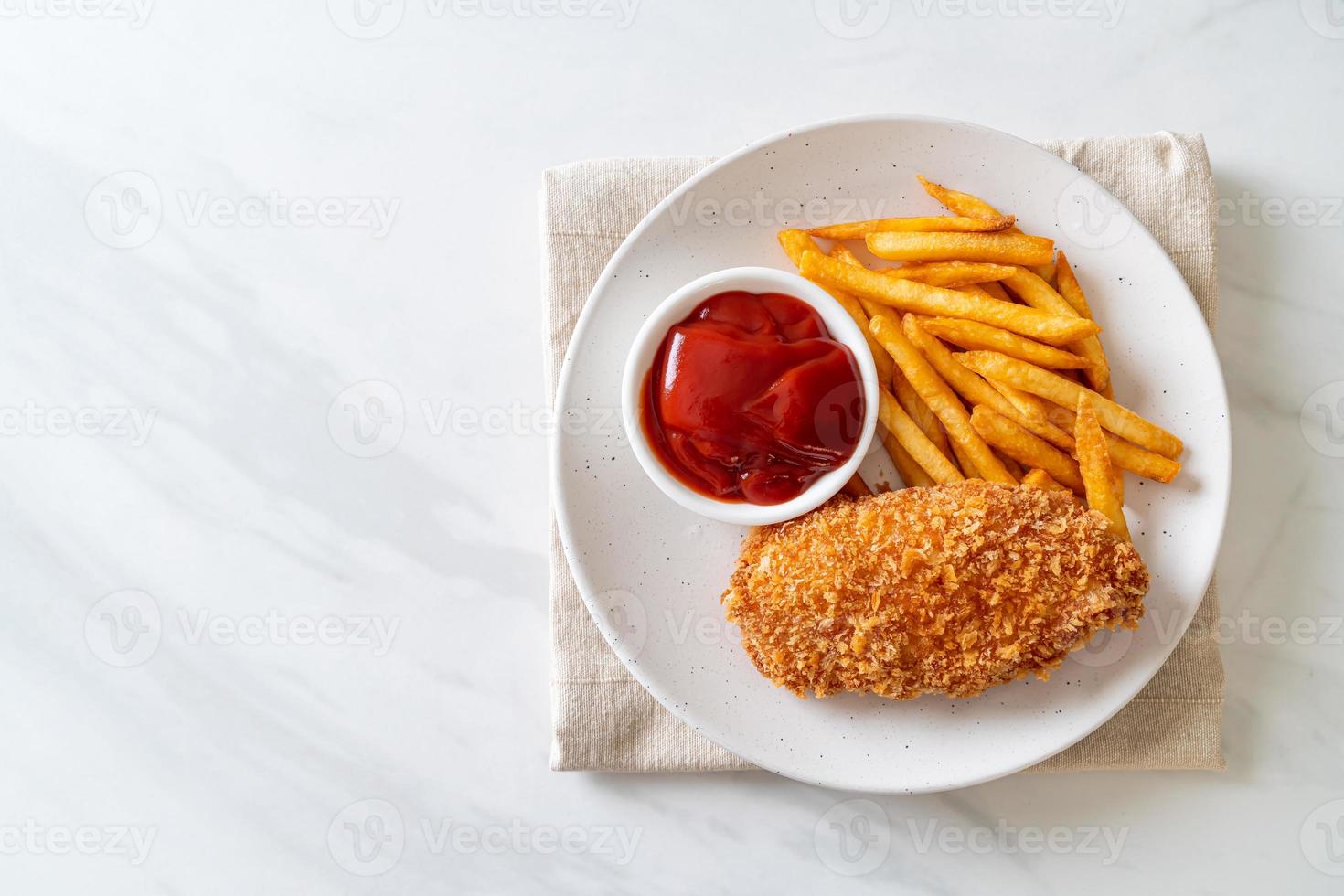 Filete de pechuga de pollo frito con papas fritas y salsa de tomate foto