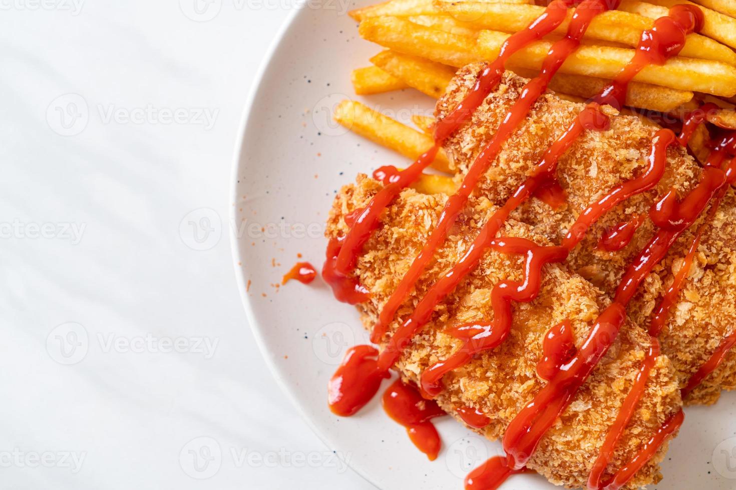 Filete de pechuga de pollo frito con papas fritas y salsa de tomate foto