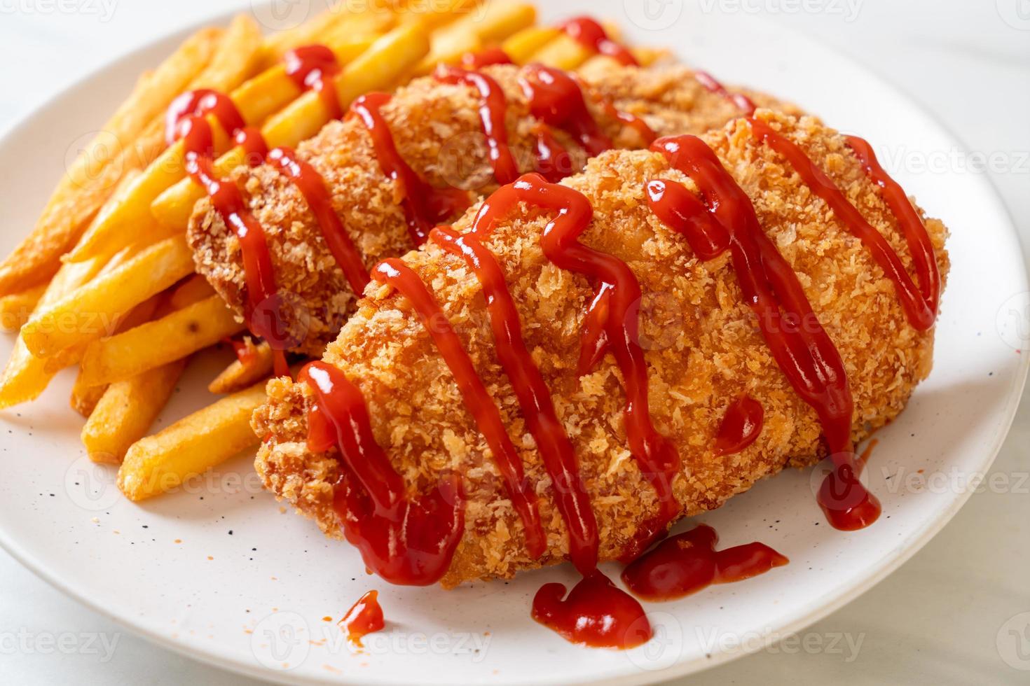 Filete de pechuga de pollo frito con papas fritas y salsa de tomate foto