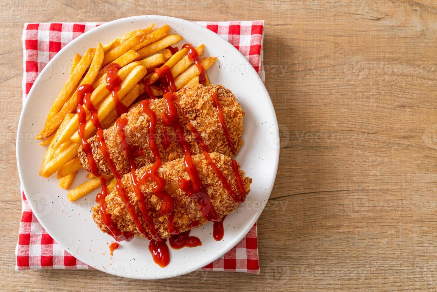 Filete de pechuga de pollo frito con papas fritas y salsa de tomate foto