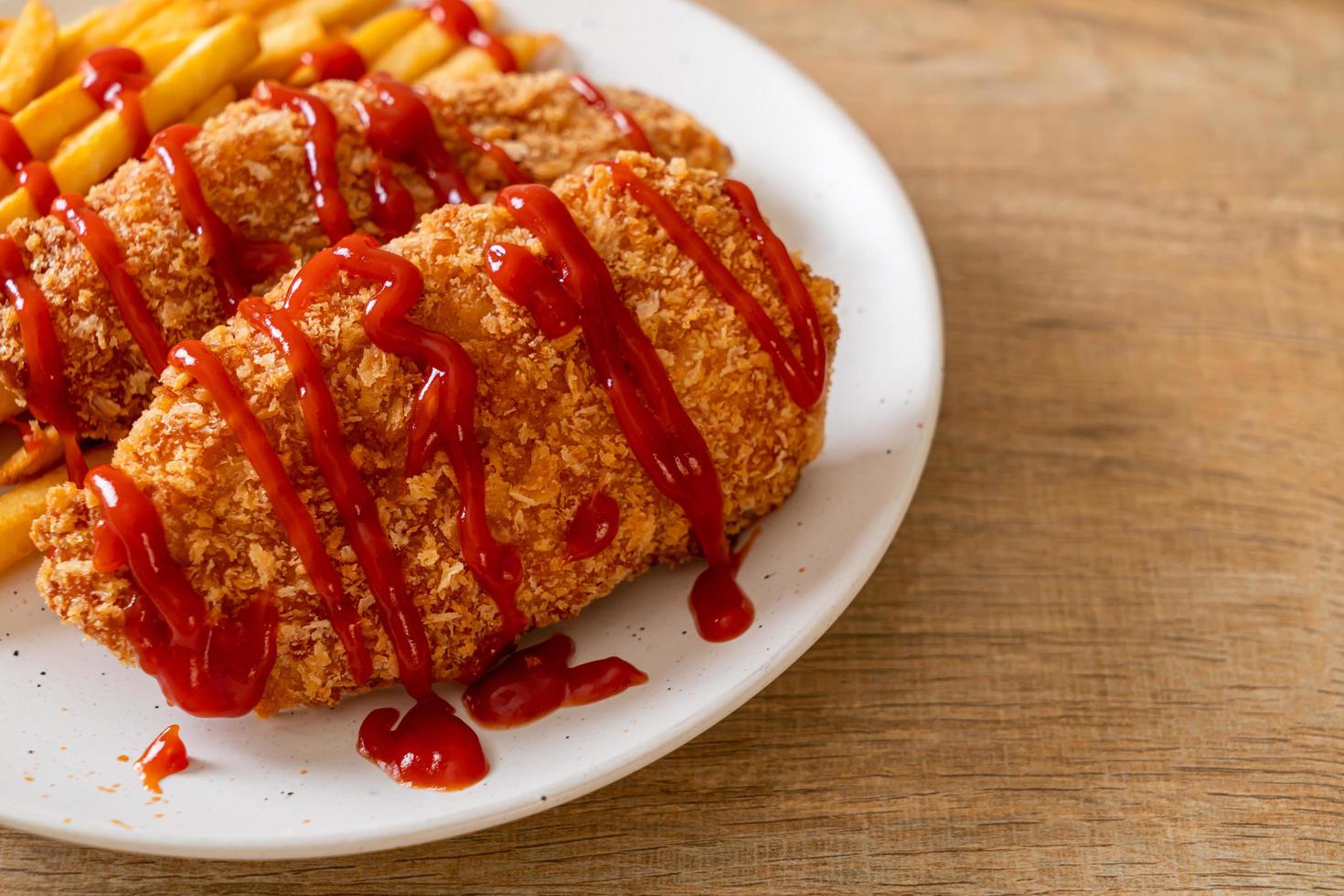 Filete de pechuga de pollo frito con papas fritas y salsa de tomate foto