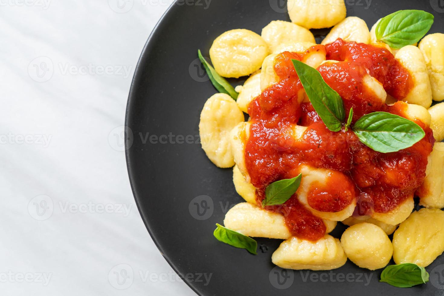 Gnocchi in tomato sauce with cheese - Italian food style photo