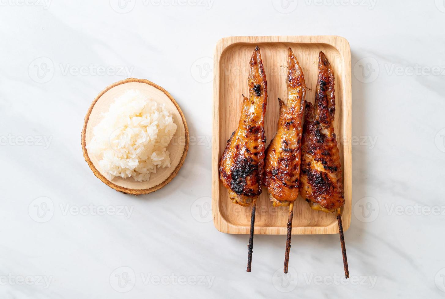 Grilled or barbecue chicken wings skewer with sticky rice photo