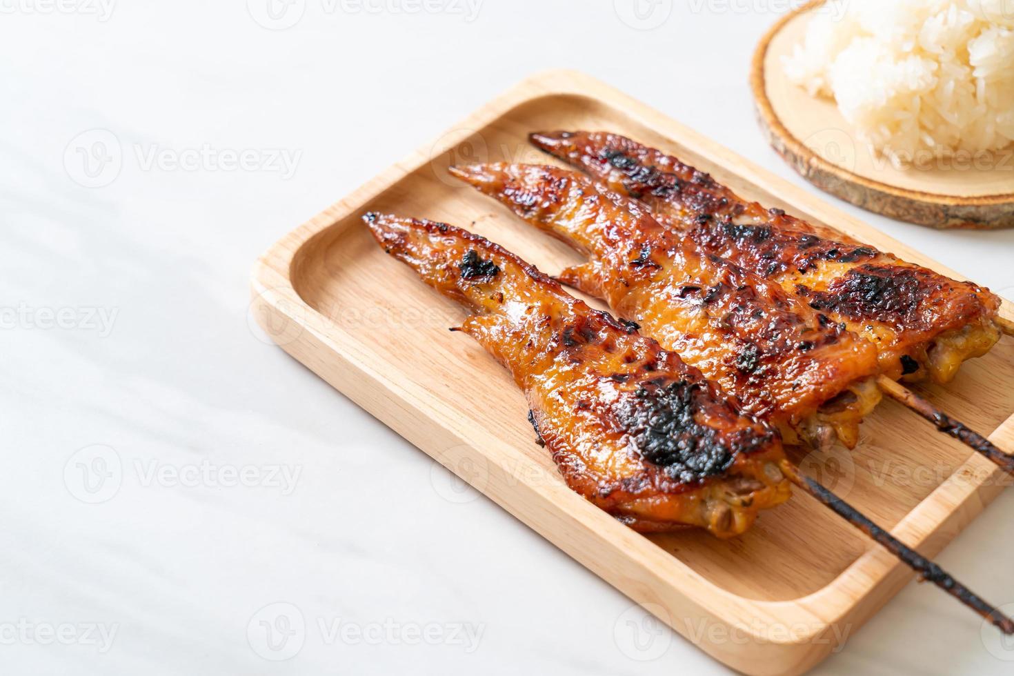 Grilled or barbecue chicken wings skewer with sticky rice photo