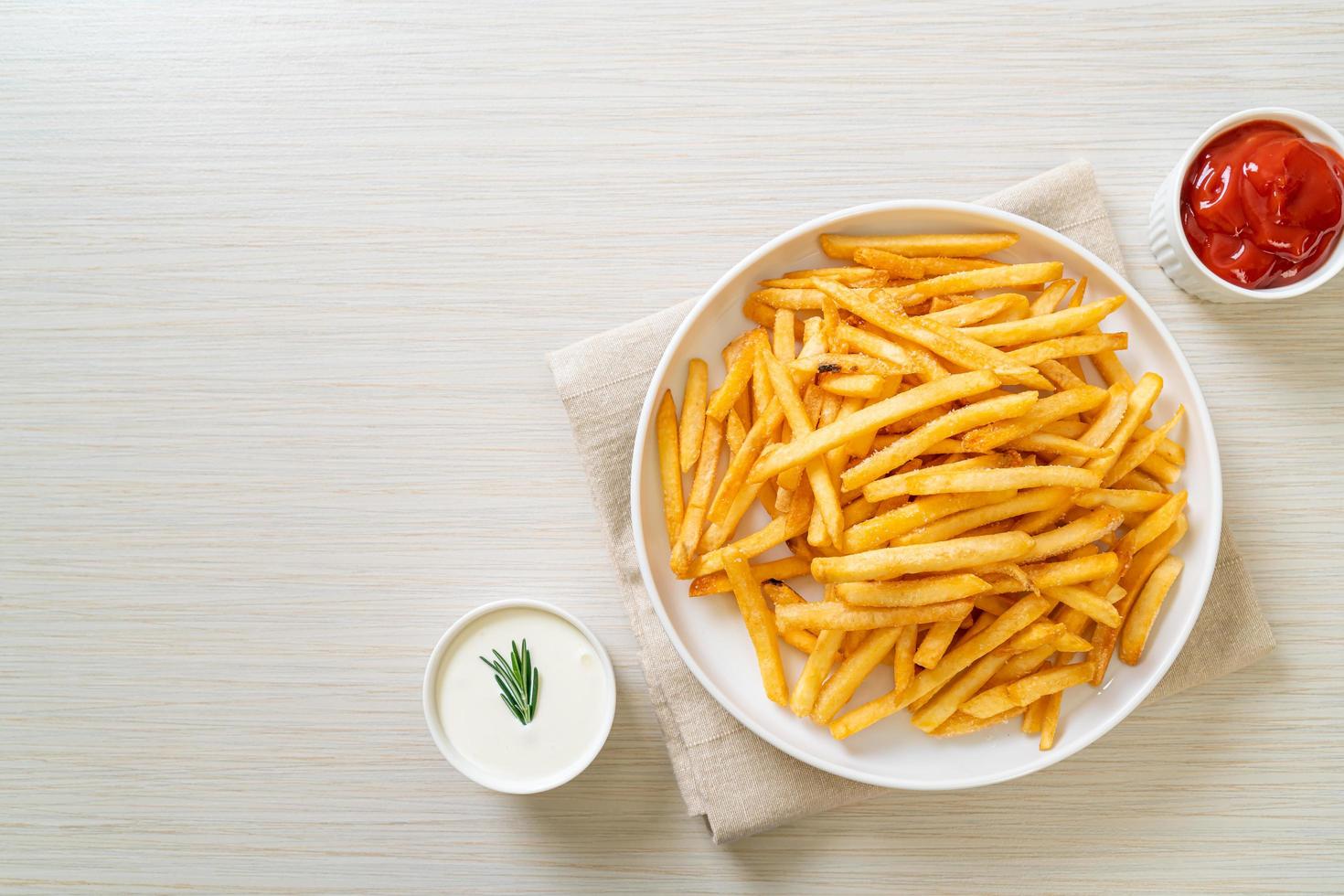 papas fritas con crema agria y salsa de tomate foto