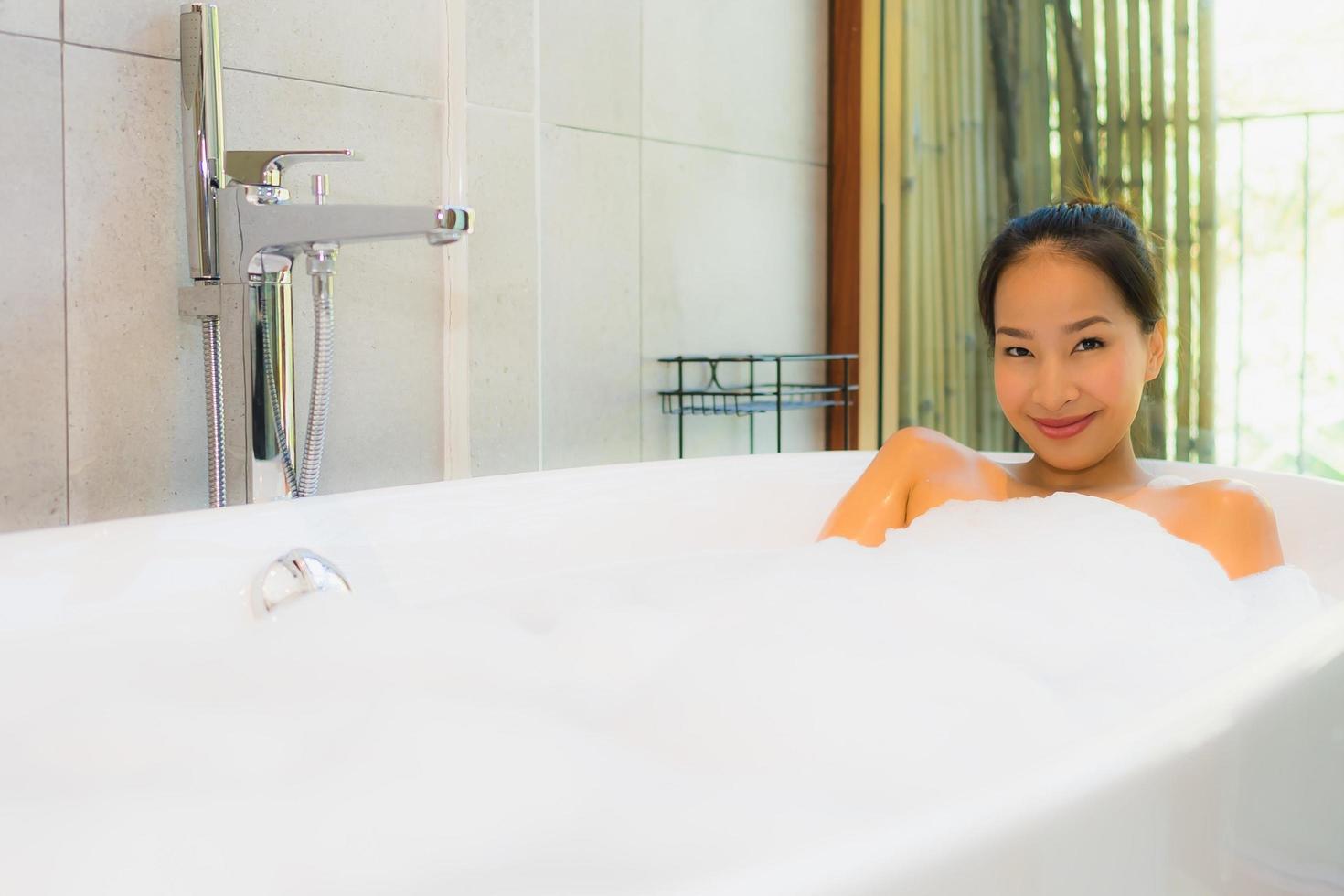Retrato joven bella mujer asiática tomar un baño en la bañera. foto