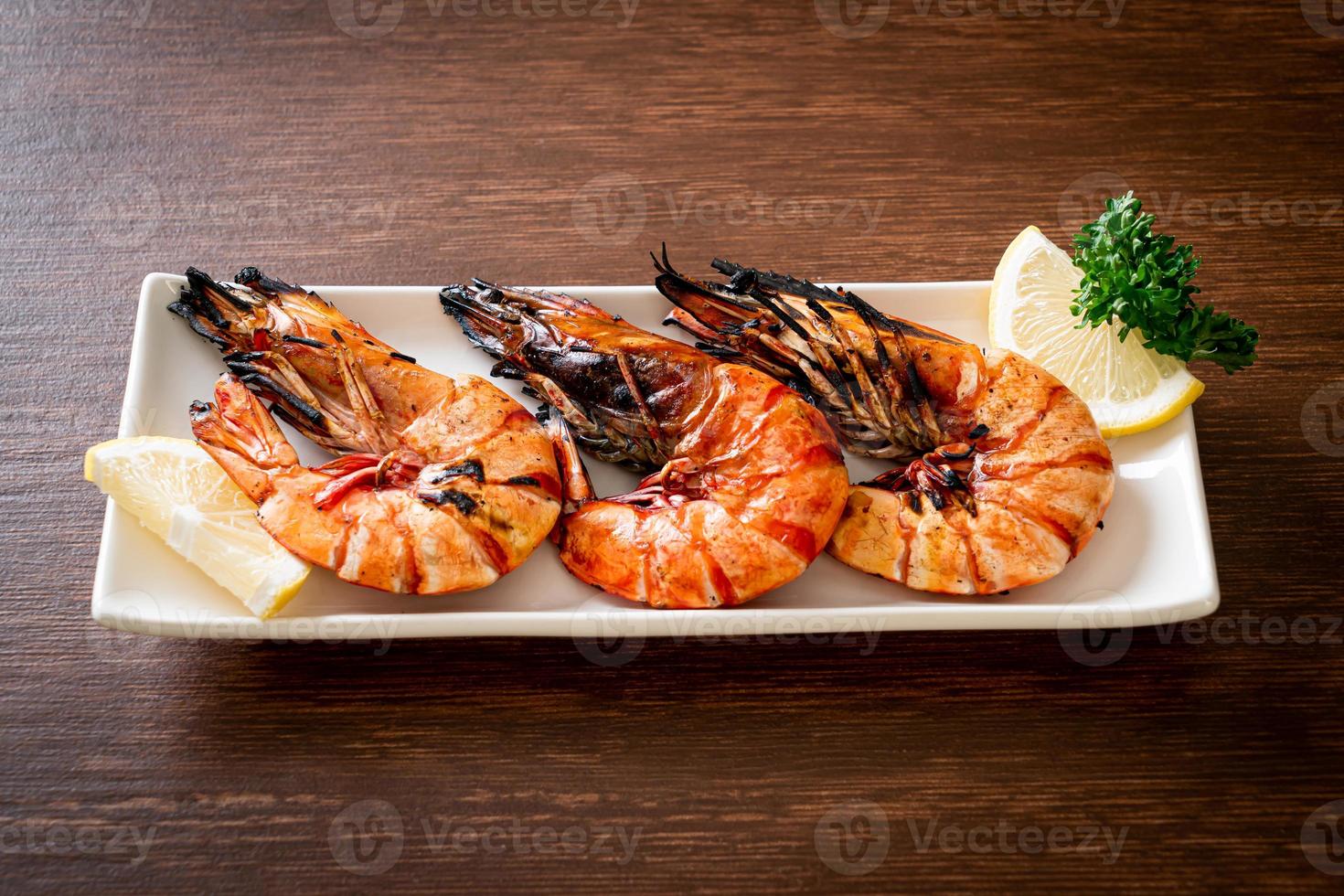 Grilled tiger prawns or shrimps with lemon on a plate photo