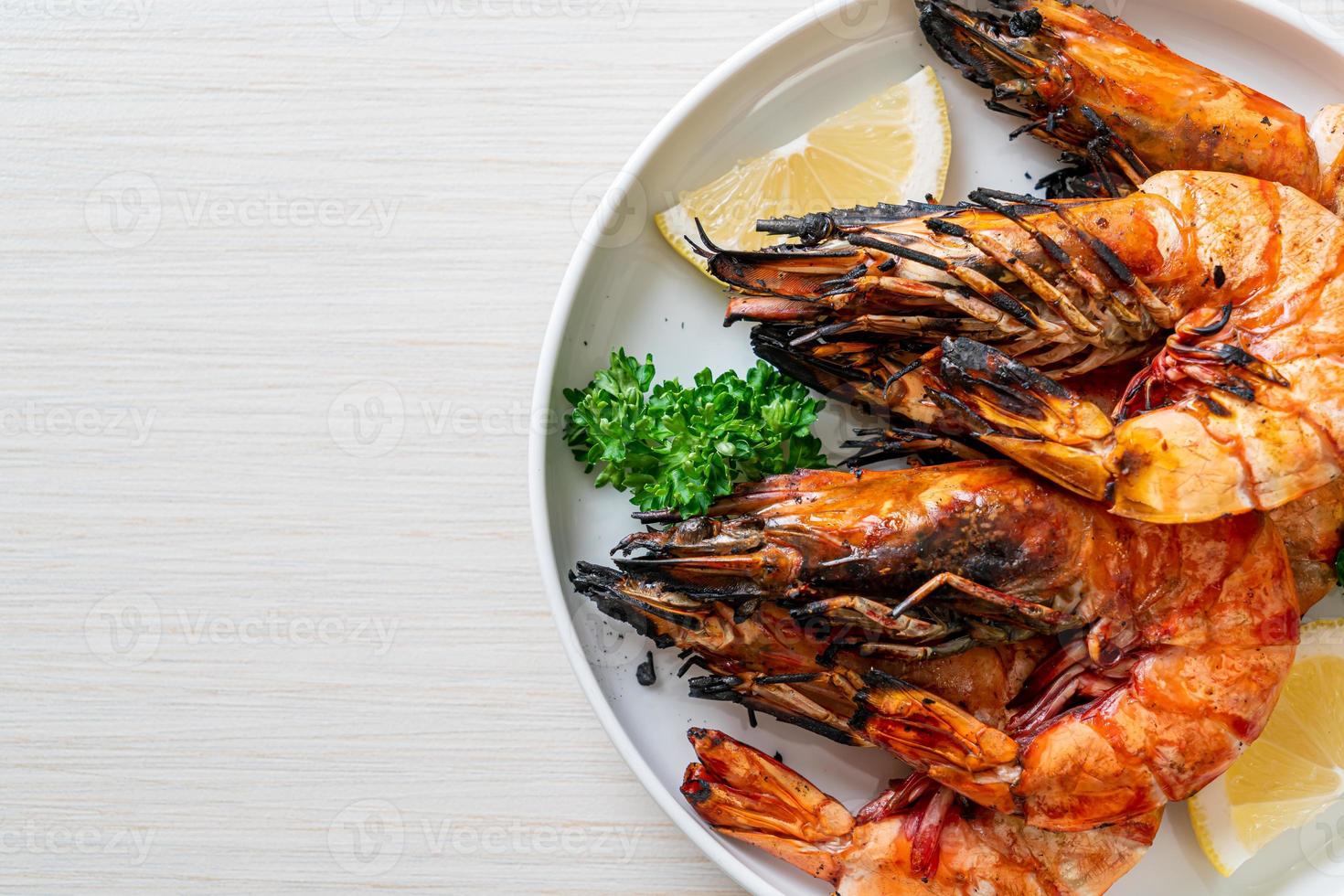 Grilled tiger prawns or shrimps with lemon on a plate photo